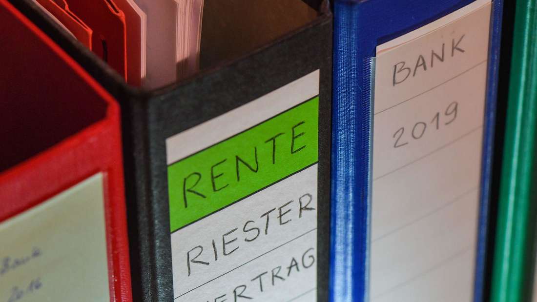 Riester pension contract documents on desk with German flag visible in background