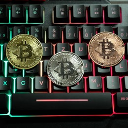 Bitcoin-Zeichen liegen auf einer Computertastatur.