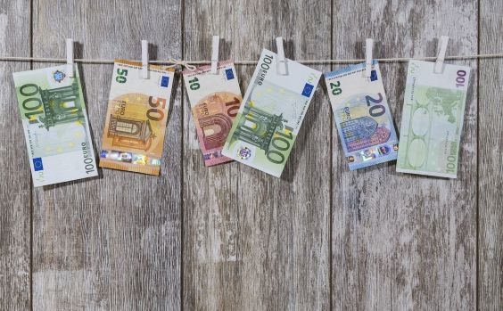 Euro banknotes arranged on a line representing financial boundaries and spending limits