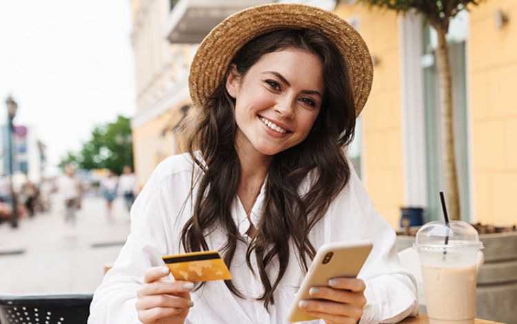 Young woman using smartphone for payment at café