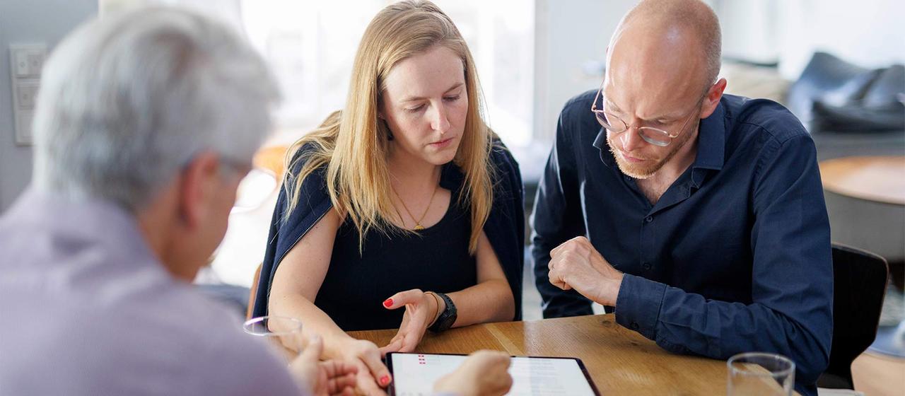Two people looking at financial data on tablet and paper representing an advisor consultation
