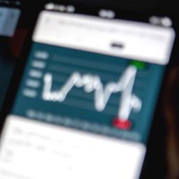 Stock market curves displayed on a smartphone screen representing pension performance