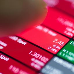 Red and green stock charts on a smartphone indicating hidden volatility and fees