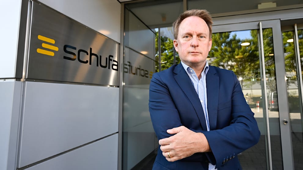 Frank Ochse stands outside the Schufa headquarters in Wiesbaden discussing the public reaction to the new scoring model