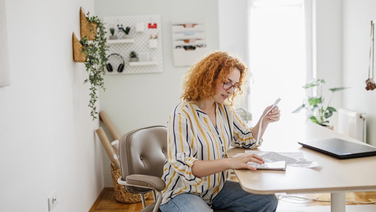 A woman reviewing her finances on a smartphone app at home