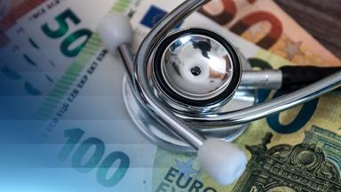 Stethoscope lying on German banknotes representing healthcare costs