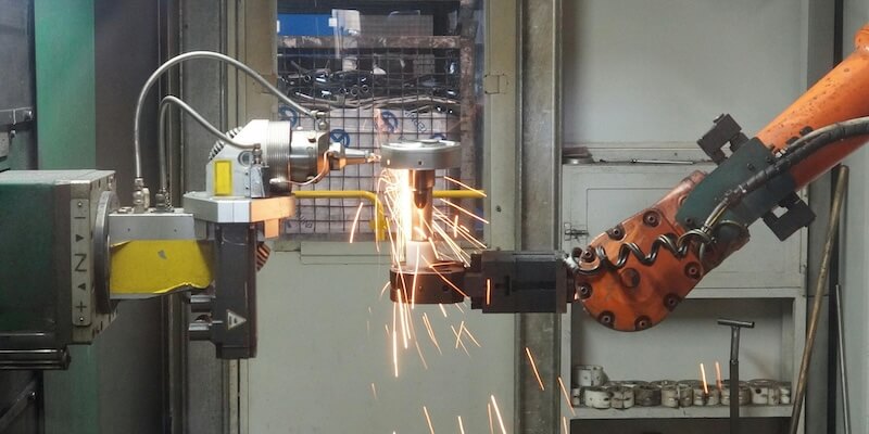 Two specialized robot systems working together with millimeter precision - symbol and article image on the topic of machine credit