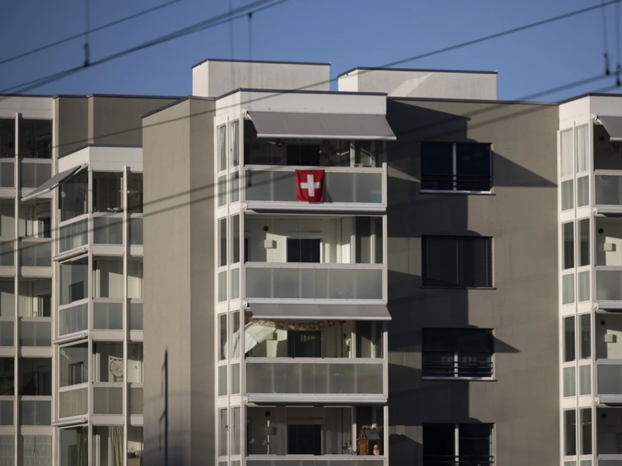 Swiss building with Swiss flag on balcony showing national property ownership culture