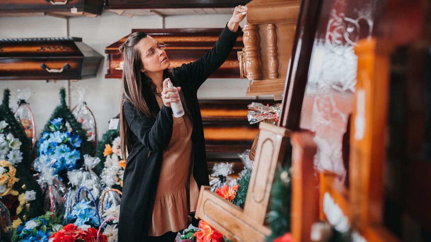 A woman showing a photo to sell a coffin and earn money