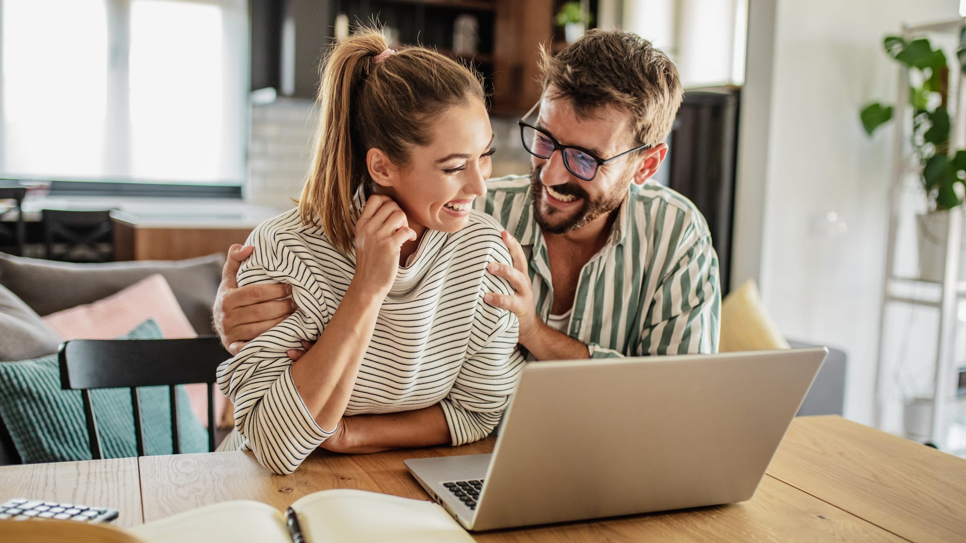 A couple sitting at home with a laptop, reviewing their finances after the ECB rate hike