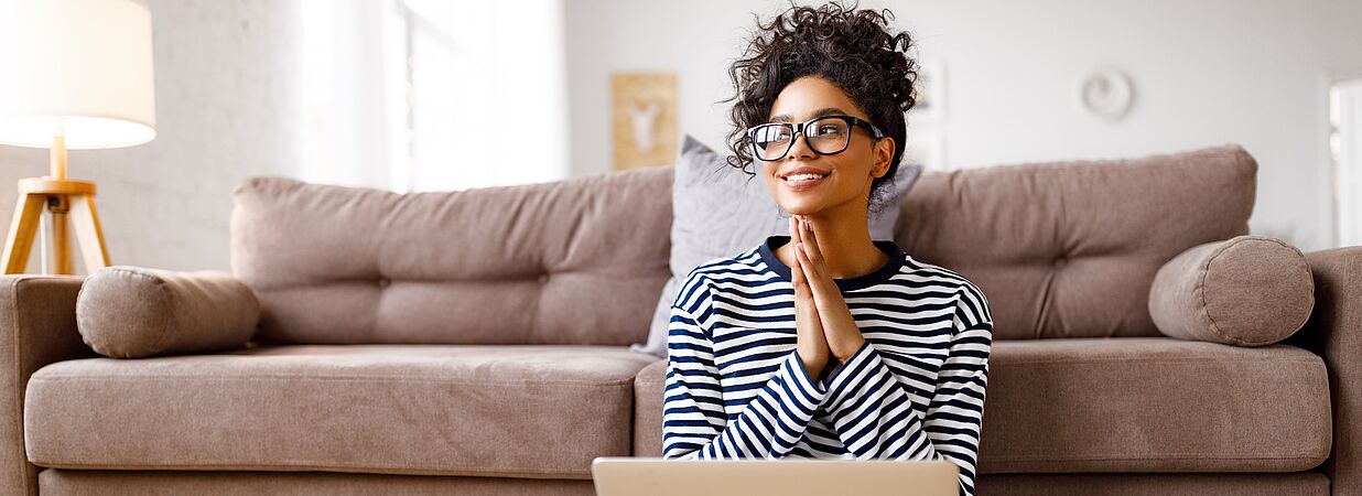Woman in deep thought while reviewing her mortgage documents on a laptop, illustrating the financial decision-making process.
